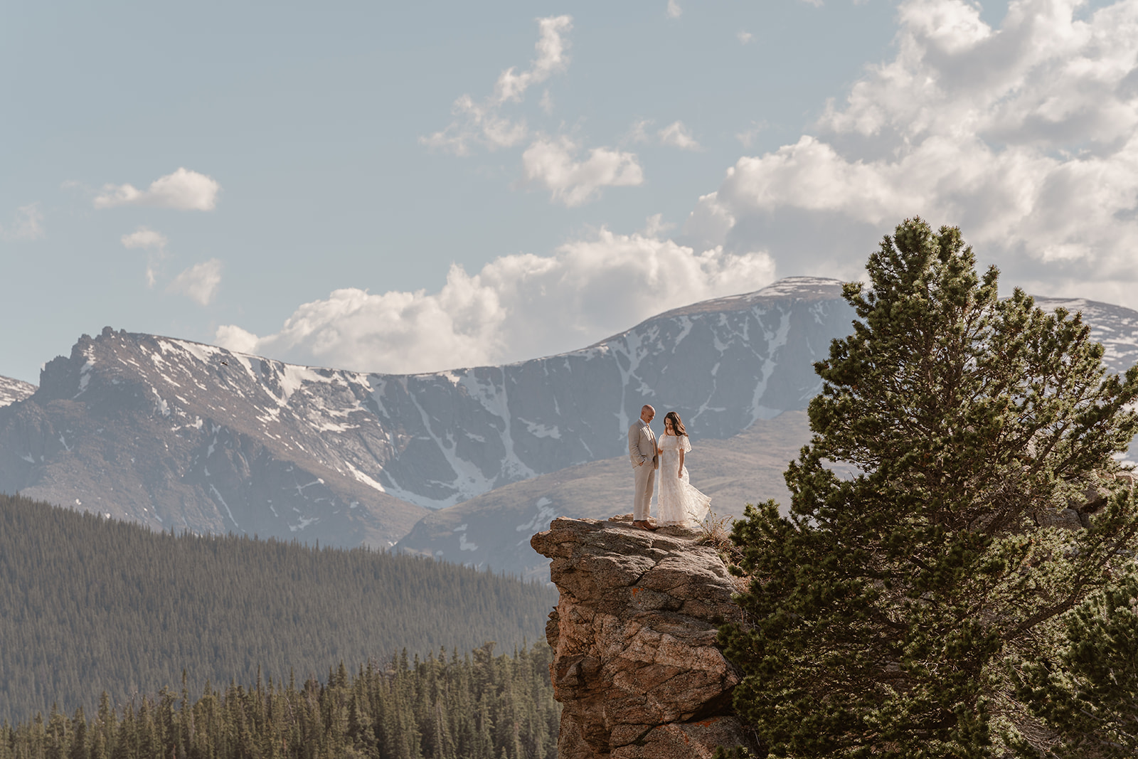 A bride and groom hold each other close atop a stunning colorado vista during their colorado adventure elopement.