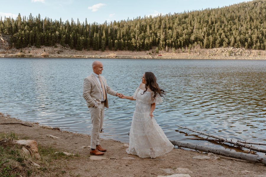 A husband and wife share their first dance around a Colorado lake as part of their Colorado adventure elopement ceremony.