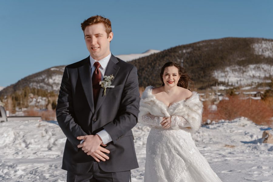 A bride approachers her groom for their first look as part of their Breckenridge winter elopement. 