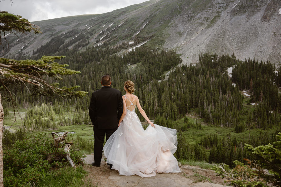 A couple takes off on their trek during their hiking elopement at Lake Isabelle. 