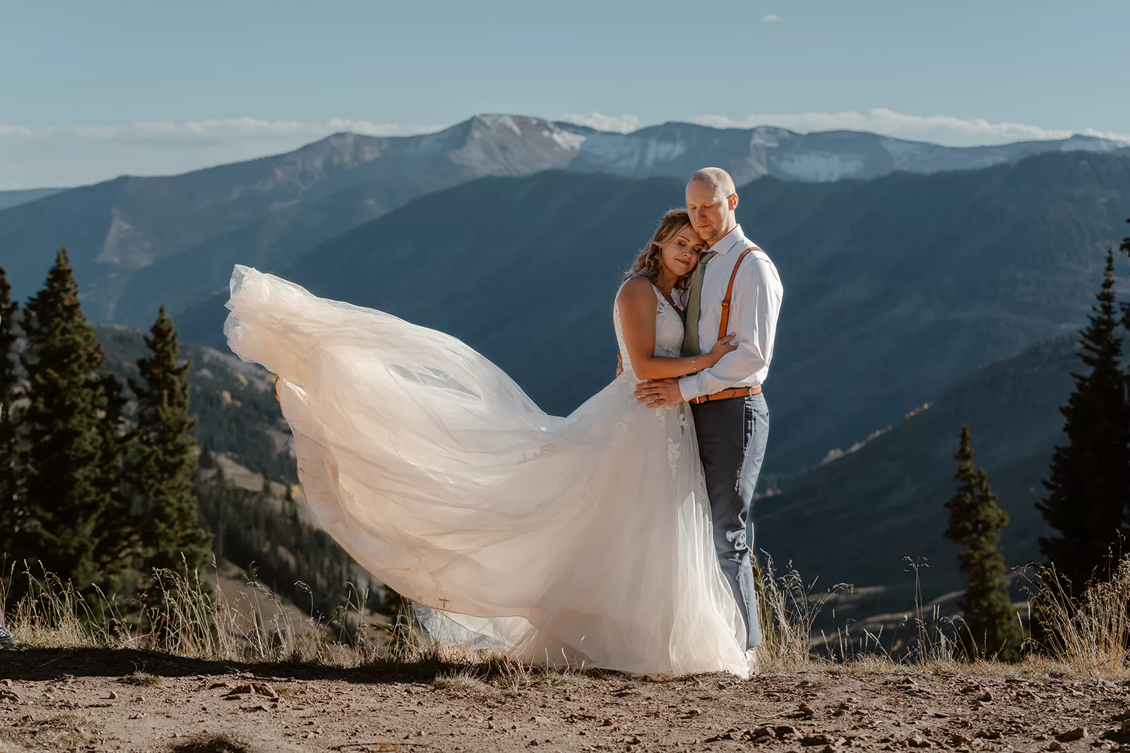 A couple hugs on top of a beautiful mountain vista in Crested Butte during their adventure elopement ceremony in Colorado.