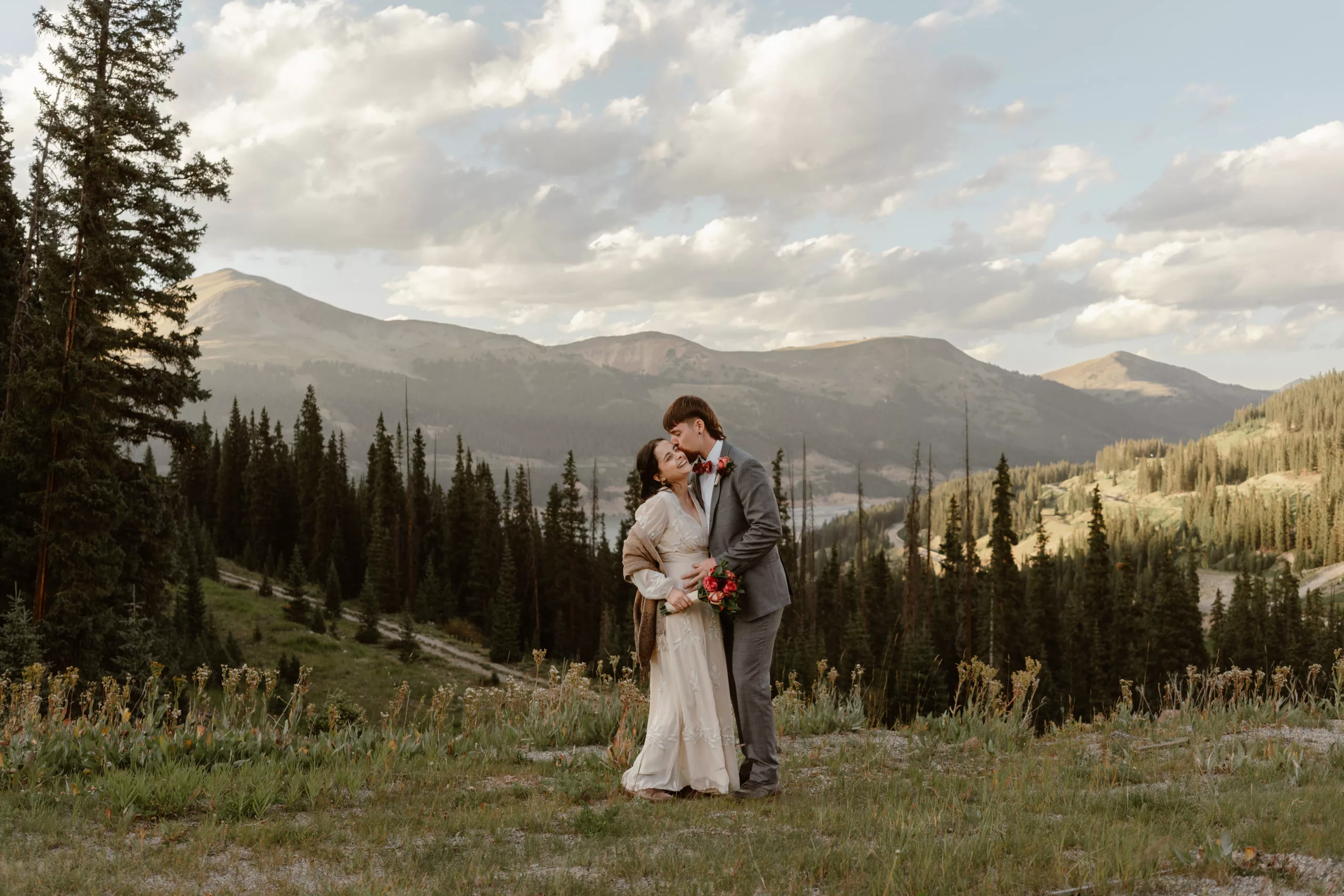 A bride and groom curl up close to each other during their Breckenridge mountain elopement.