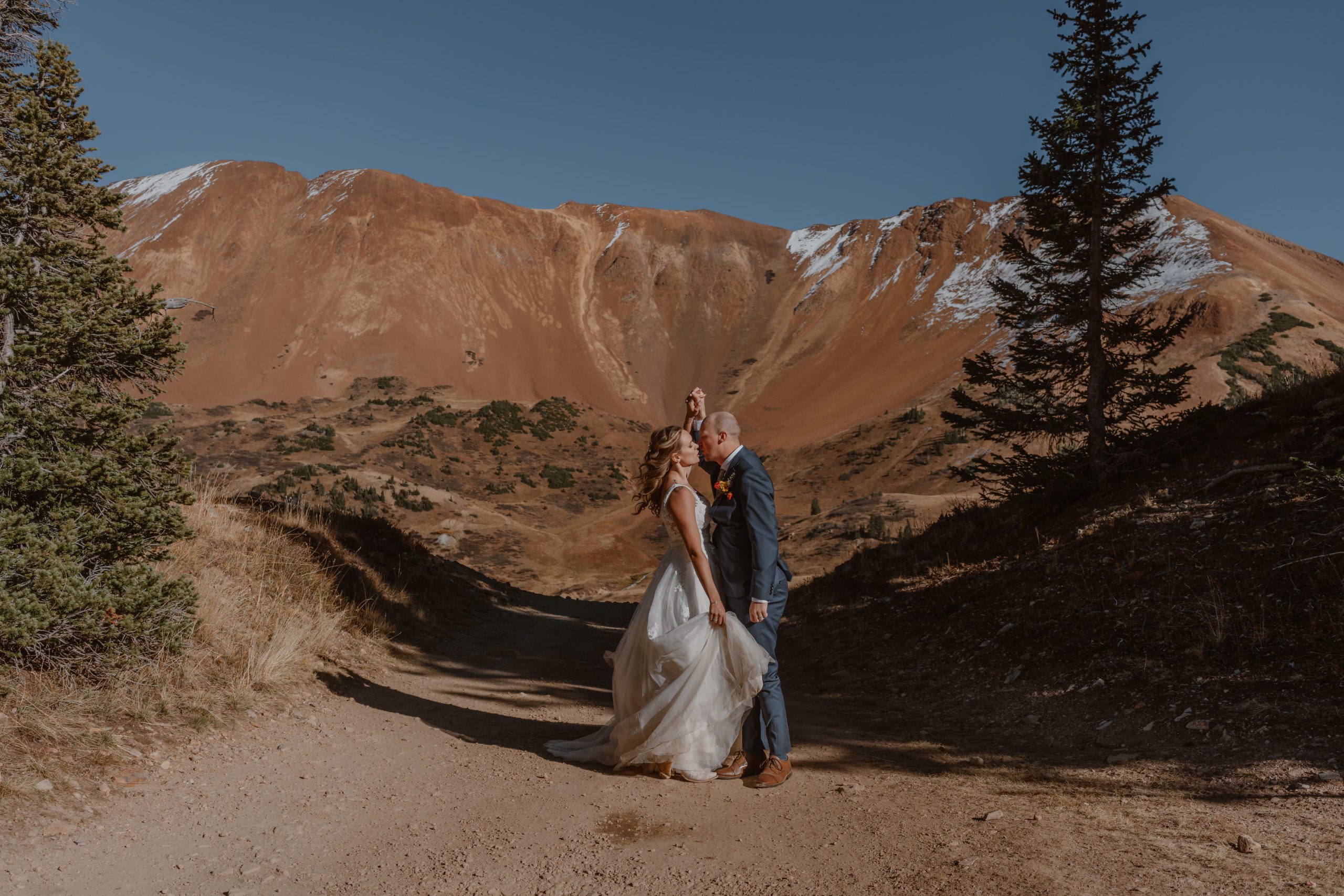 A bride and groom have their first dance on a mountain road during their Fall Crested Butte elopement.