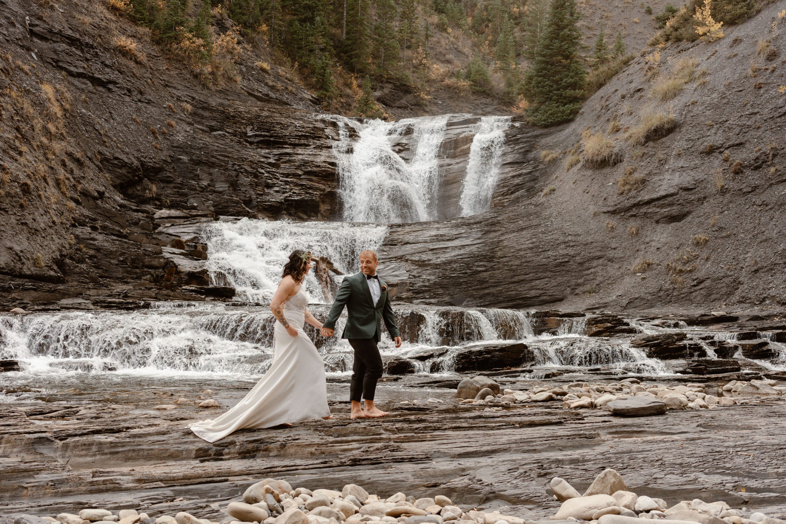 A bride and groom explore during their Colorado waterfall elopement in Crested Butte.