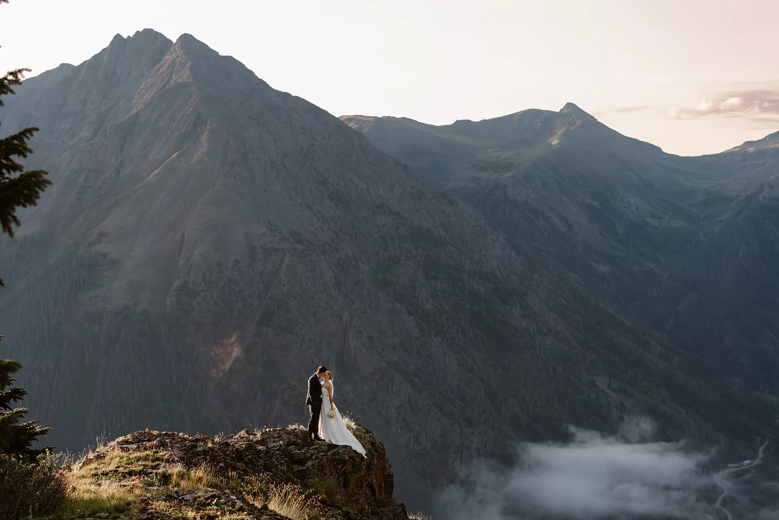 A bride and groom pose as the alpenglow comes up during their san juan mountain elopement.