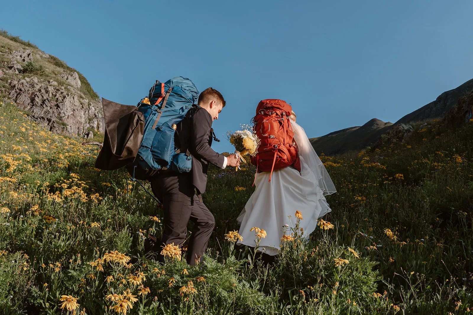 A couple hikes up the mountain for their elopement ceremony during their San Juan mountain elopement.