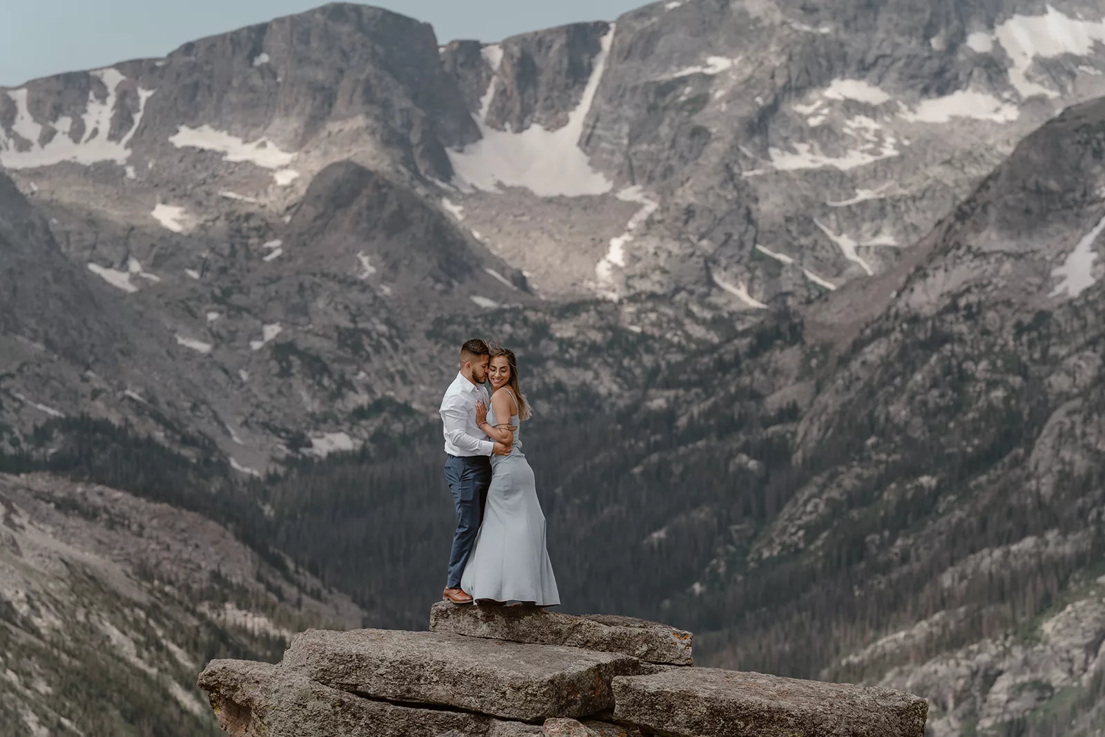 A man and woman spend a moment together on a Colorado mountaintop during their RMNP proposal.