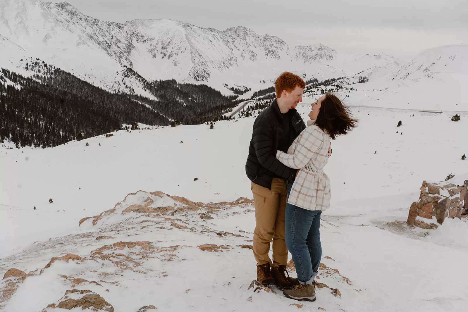 A man and a woman hold each other close on Loveland pass during their Breckenridge engagement session.