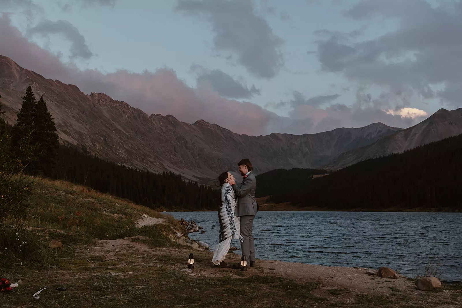 A bride and groom stand at the water's edge of a Colorado lake during their adventure elopement, following along with their elopement timeline plan.