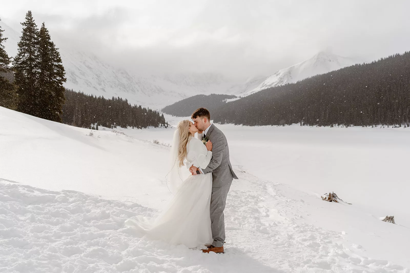 A bride and groom embrace in the snowy mountain town of Breck while enjoying their skiing adventure elopement.