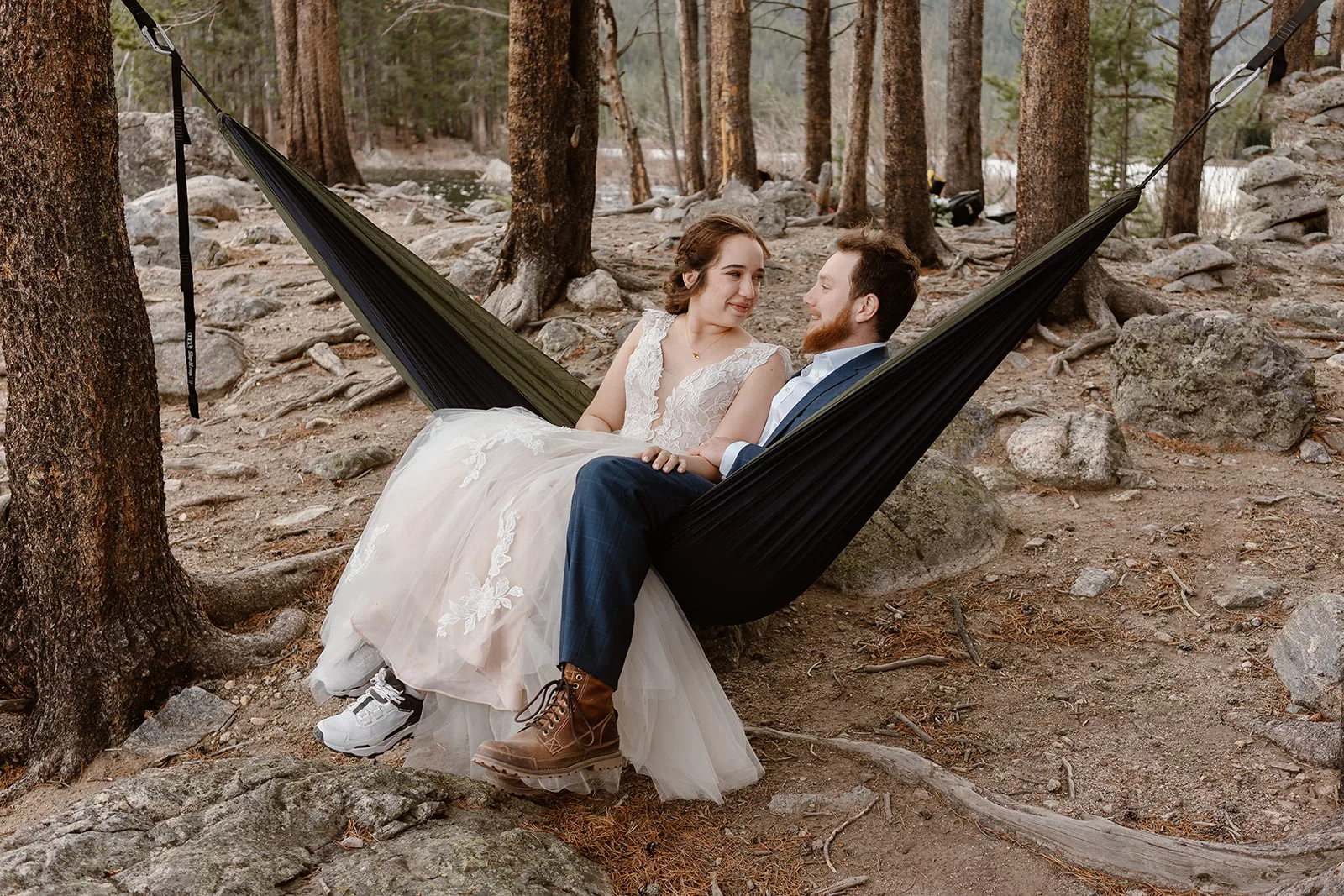 A bride and groom share a stress-free moment in a hammock during their adventure elopement, a moment their wedding coordinator helped them plan.