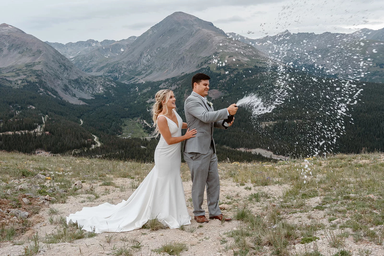 A couple pops champagne during their elopement ceremony at their Breckenridge adventure elopement.
