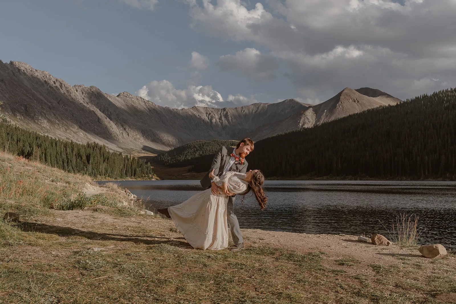 A couple embraces and dips during their elopement ceremony, a self-solemnization adventure elopement in Colorado.