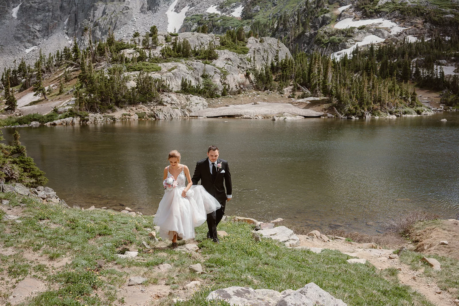 An eloping couple takes their time hiking up to Lake Isabelle during their adventure elopement.