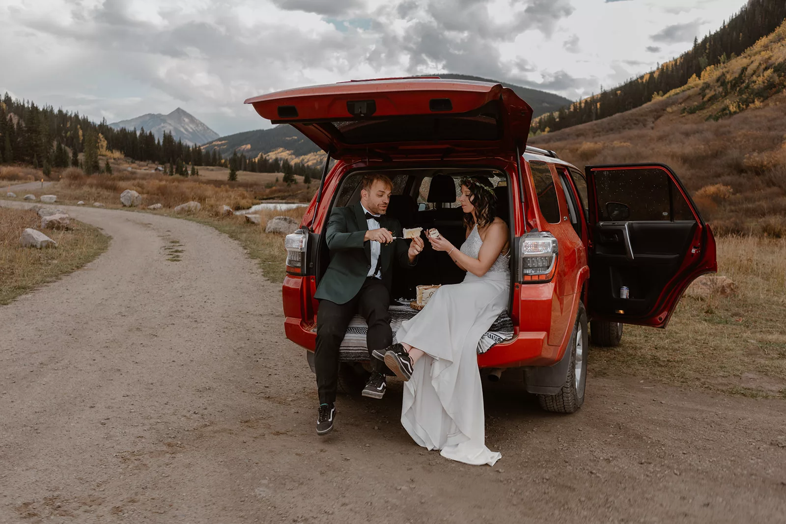 A couple eats cake as they enjoy the San Juan Mountain views during their San Juan mountain elopement.