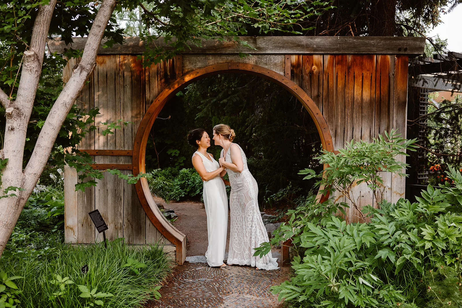 Two brides lean in close for a kiss on their wedding day, a private elopement in Colorado.