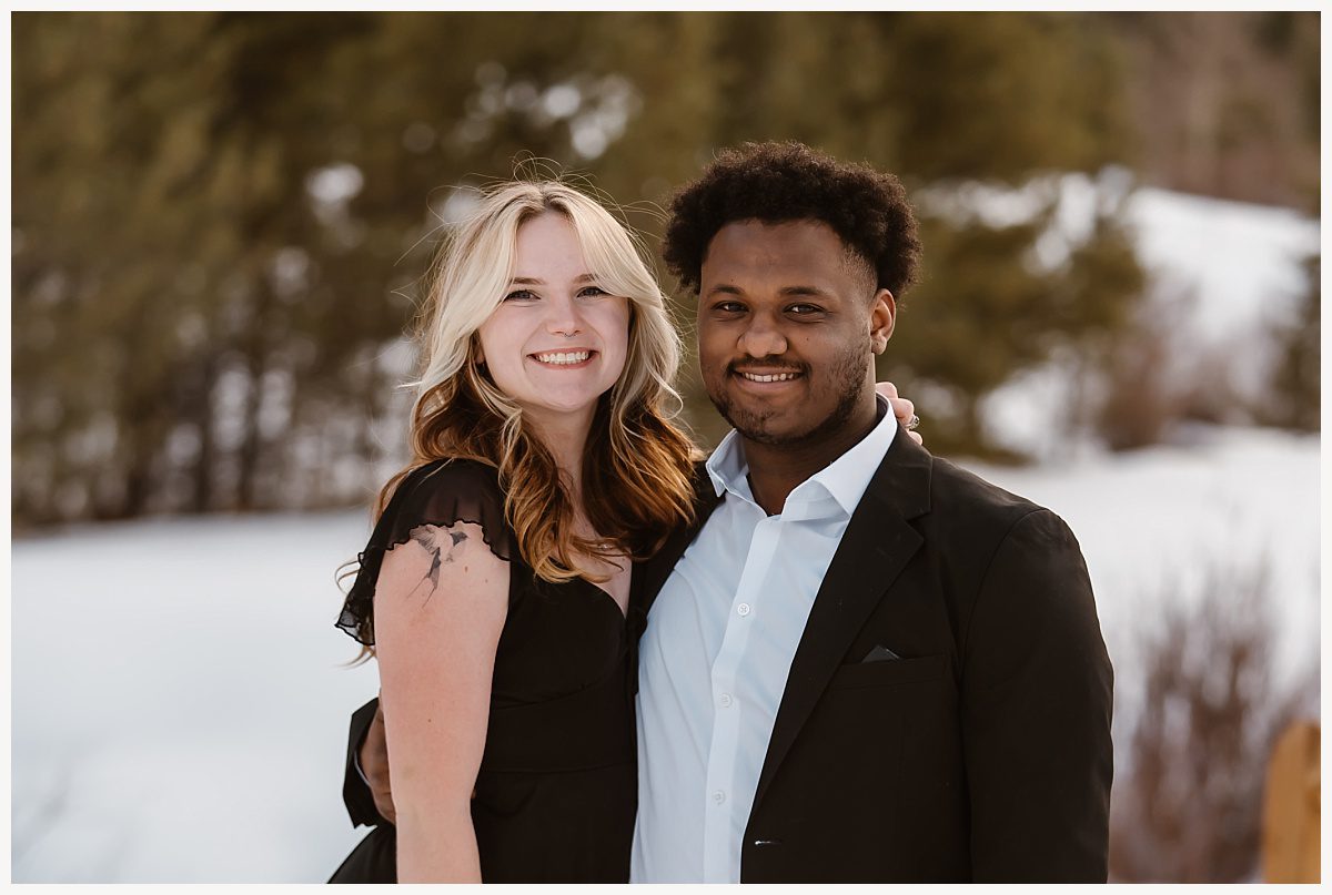 Couple smiling as snow falls gently during their Breckenridge proposal