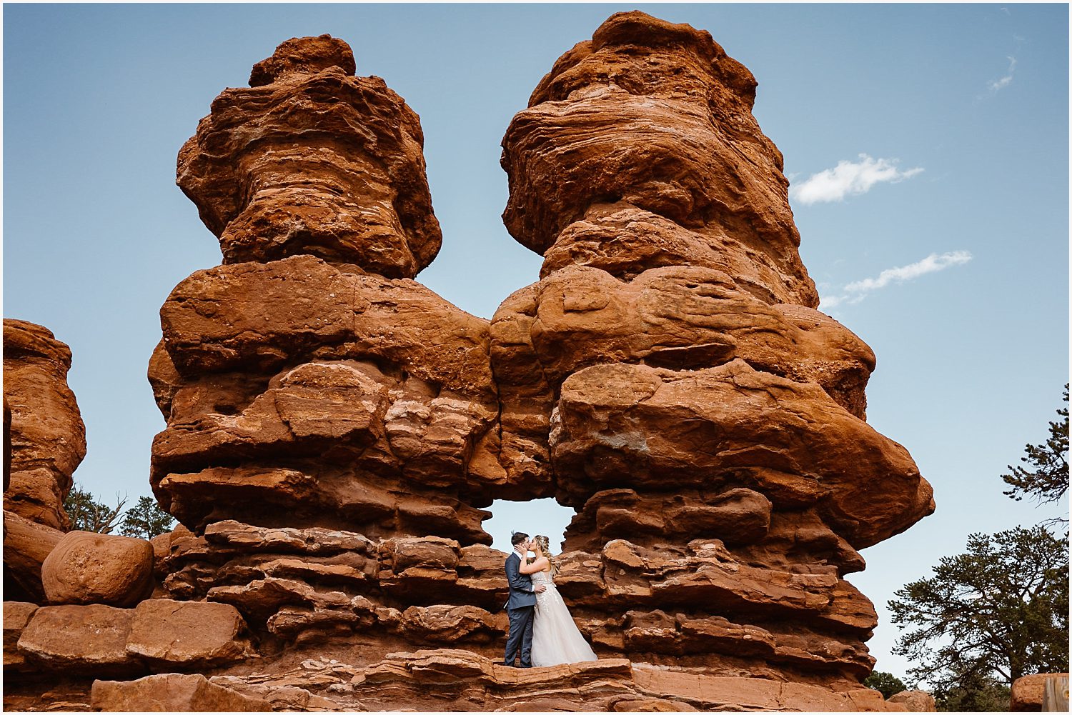 A bride twirls in her flowing dress as her partner watches with admiration, showcasing a mix of natural movement and stunning portraiture.