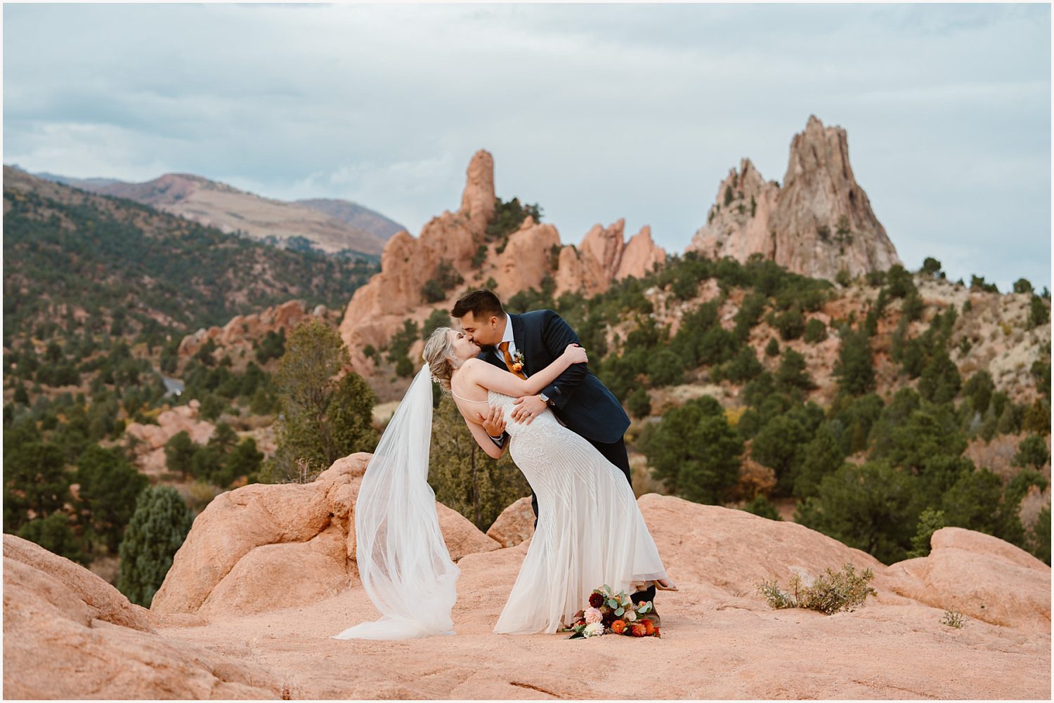 A candid moment of a couple laughing as they navigate a rocky trail together, capturing the essence of adventure elopements.